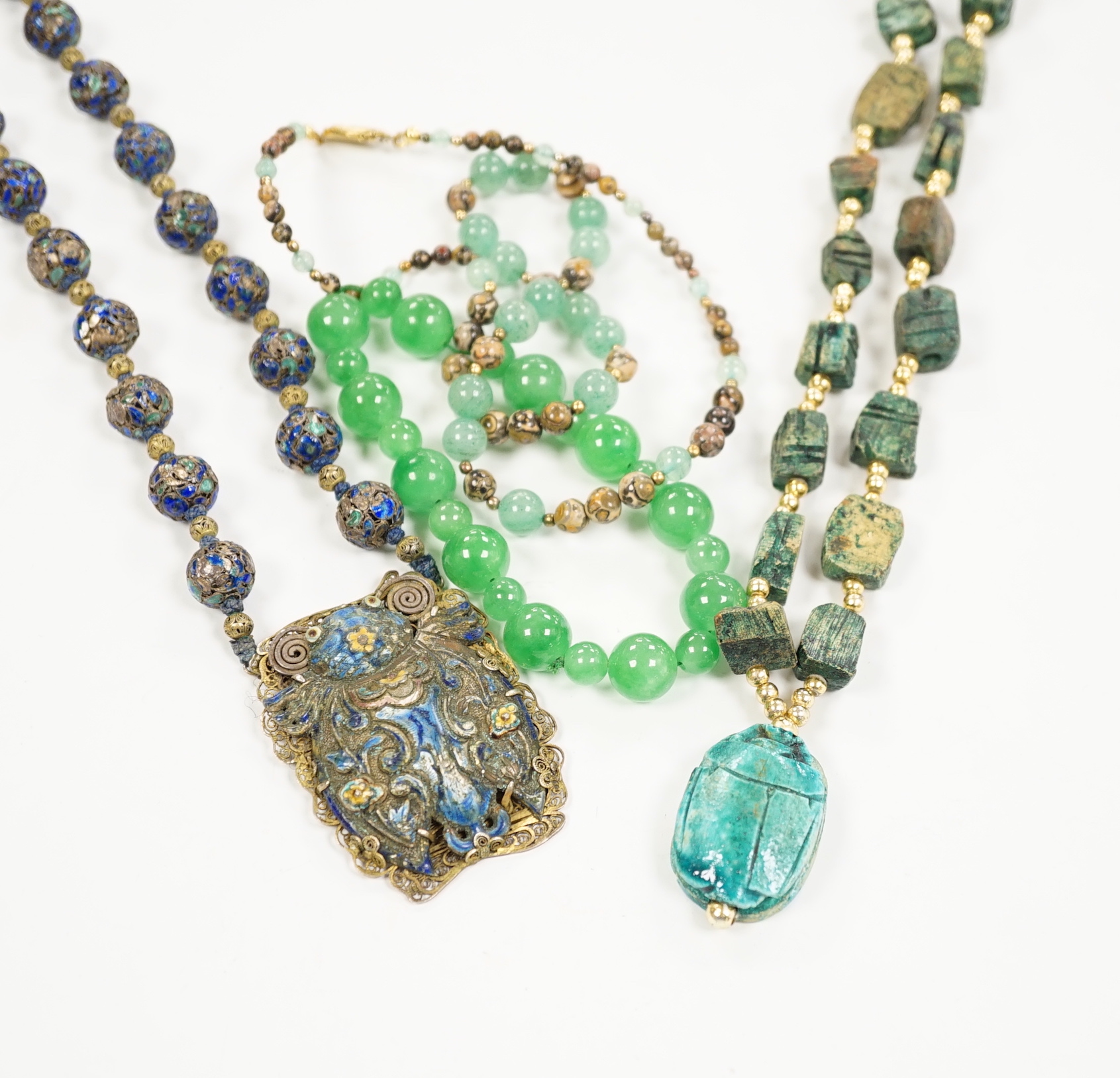Three assorted Chinese bead necklaces including filigree gilt white metal and enamel pendant necklace, overall 68cm and a jade bracelet.